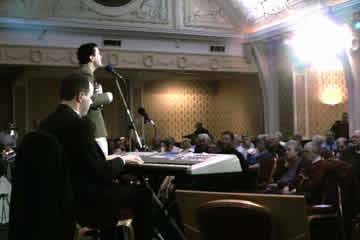 Matthew Sproston entertains a large audience (video still)